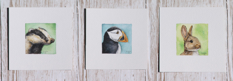 Miniature wildlife paintings of a badger, puffin and rabbit