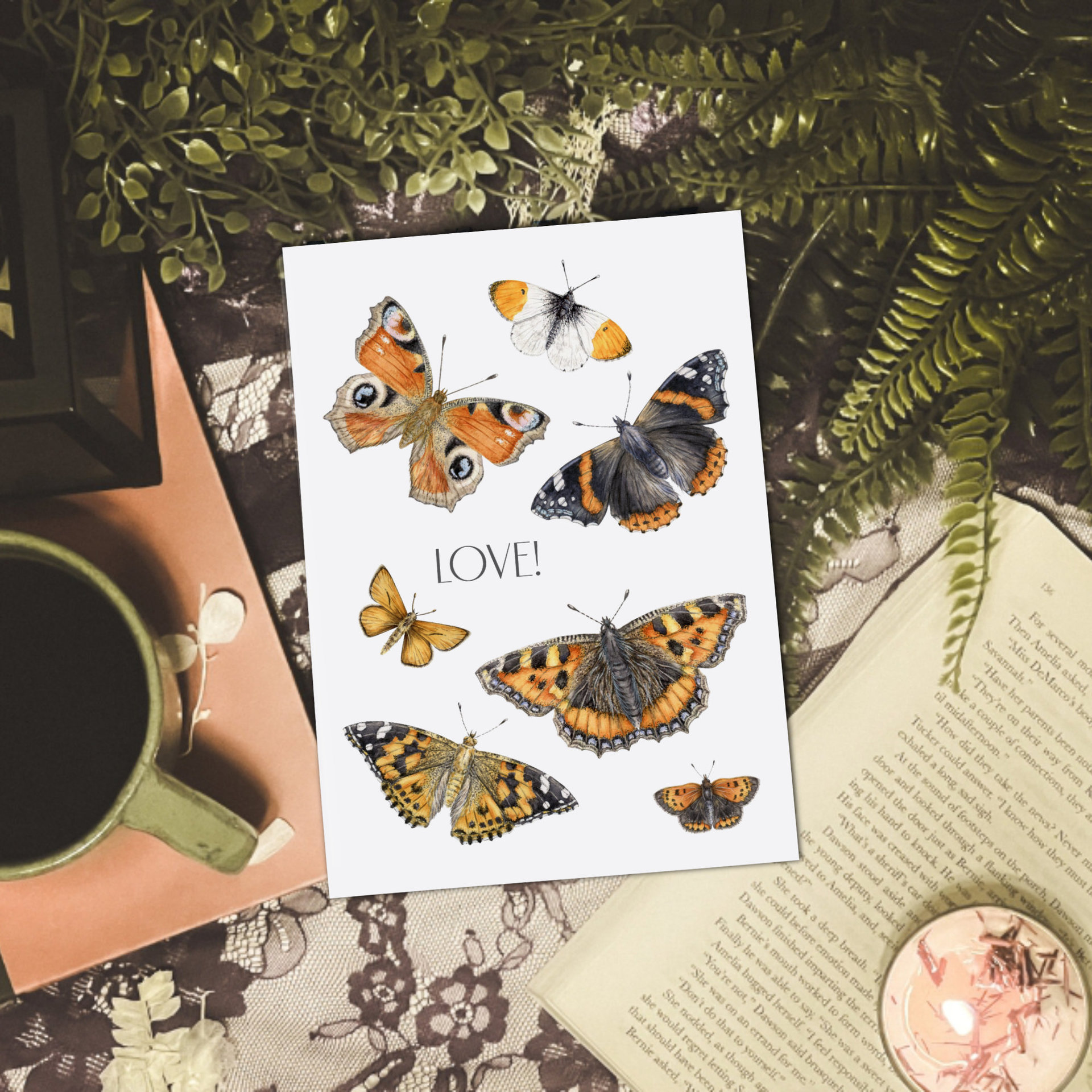 Butterfly art print on a table with coffee, books and plants