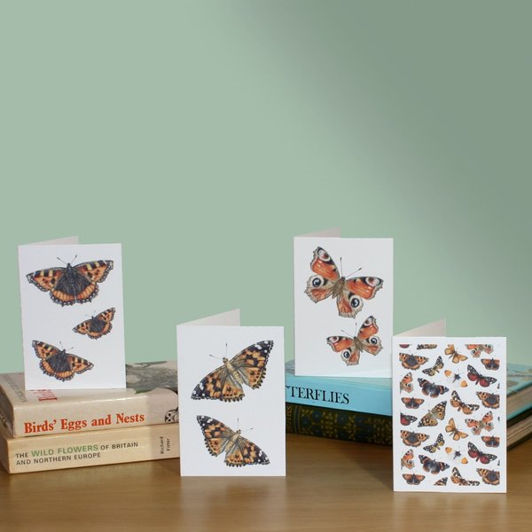 Butterflies mini note cards sitting on piles of books with a green background
