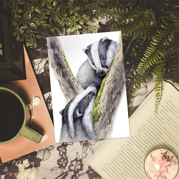 Badger watercolour print sitting on a table with coffee, books and plants