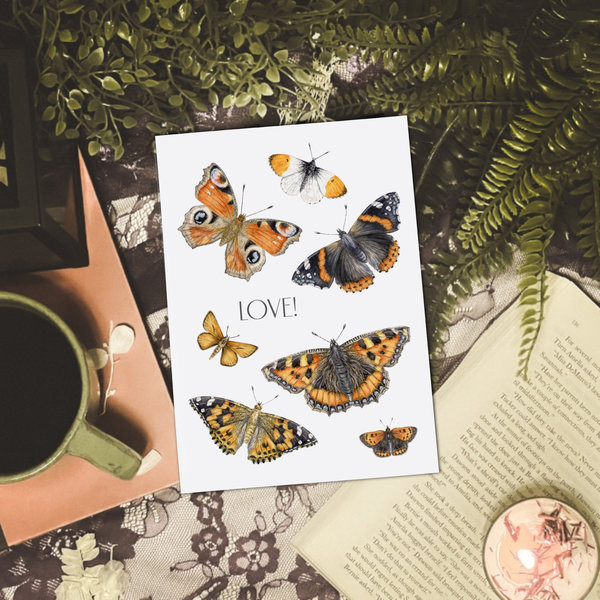 Butterfly art print on a table with coffee, books and plants