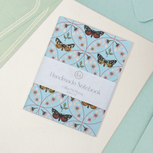 Moth pattern notebook with belly band detailing what it is